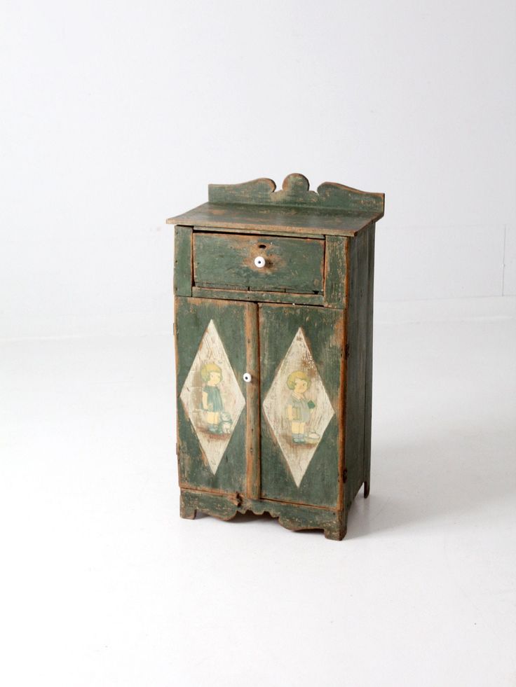 an old green cabinet with diamond designs on the front and sides, against a white background