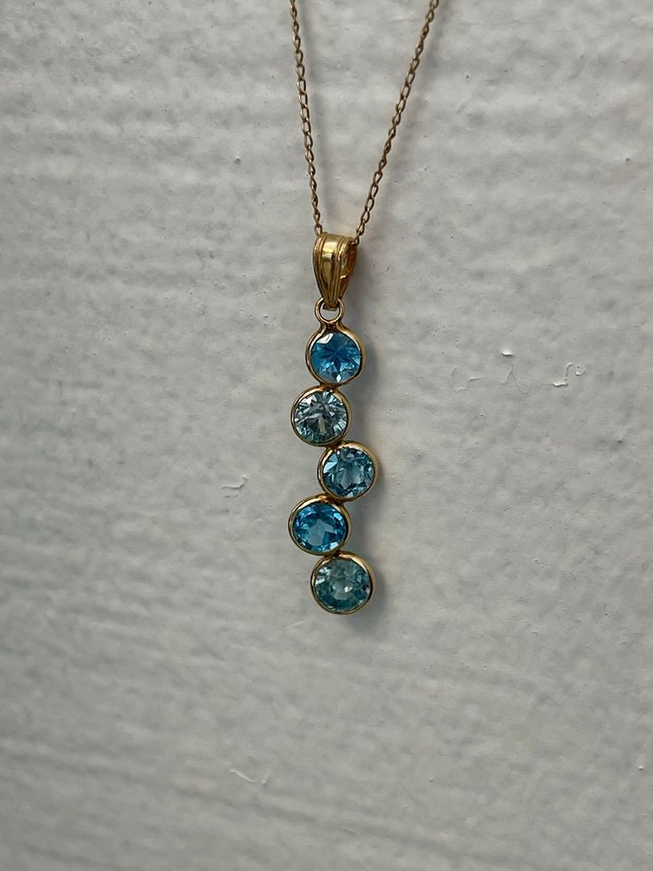 "PENDANT IS READY TO SHIP  TOPAZ JOURNEY PENDANT IN 14kt YELLOW GOLD Metal: 14KT gold Center Stone: Natural topaz Color: Blue Approximate Weight: 10ct Gram(s) weight: 3.00 grams Gemstone Size: 4MM Clarity: Eye clean-AAA grade Cut: round Size: 1 inch long app. We offer layaway payments please contact us we are flexible. ABOUT US We are a family-owned business. My name is Margarita Sciapin and I am the designer behind the jewelry we make, my husband Maxim Sciapin is the one that takes my vision and makes it a reality. Maxim is a worldwide known jeweler and diamond setter. His workmanship is often complimented in magazines and blogs, his setting style is known as: \"machine like\" for its precision and quality. We make our designs minimal and modern utilizing luxurious earth materials such as Yellow Gold Topaz Gemstone Necklace, Yellow Gold Topaz Gemstone Necklaces, Fine Jewelry Yellow Gold Topaz Necklace, Yellow Gold Topaz Pendant Jewelry, Yellow Gold Topaz Necklace Fine Jewelry, Gold Faceted Gemstone Pendant, Yellow Gold Topaz Necklace With Round Pendant, Yellow Gold Necklace With Round Topaz, Yellow Gold Topaz Round Necklace