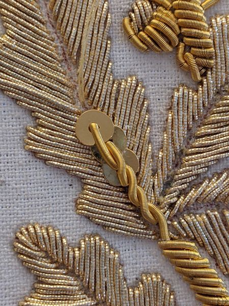 some gold leaves are on a white cloth