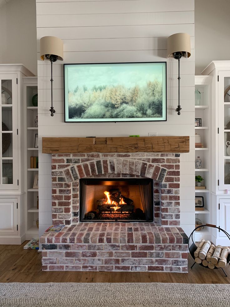 a fire place in a living room with a painting on the wall above it's fireplace