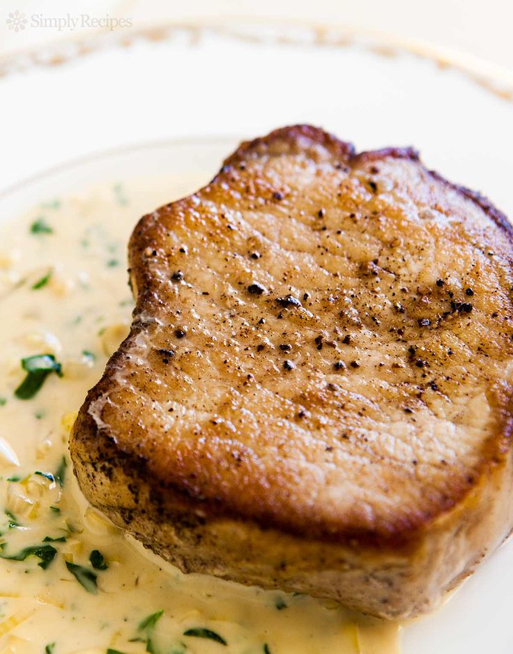 a piece of meat is sitting on top of mashed potatoes and gravy