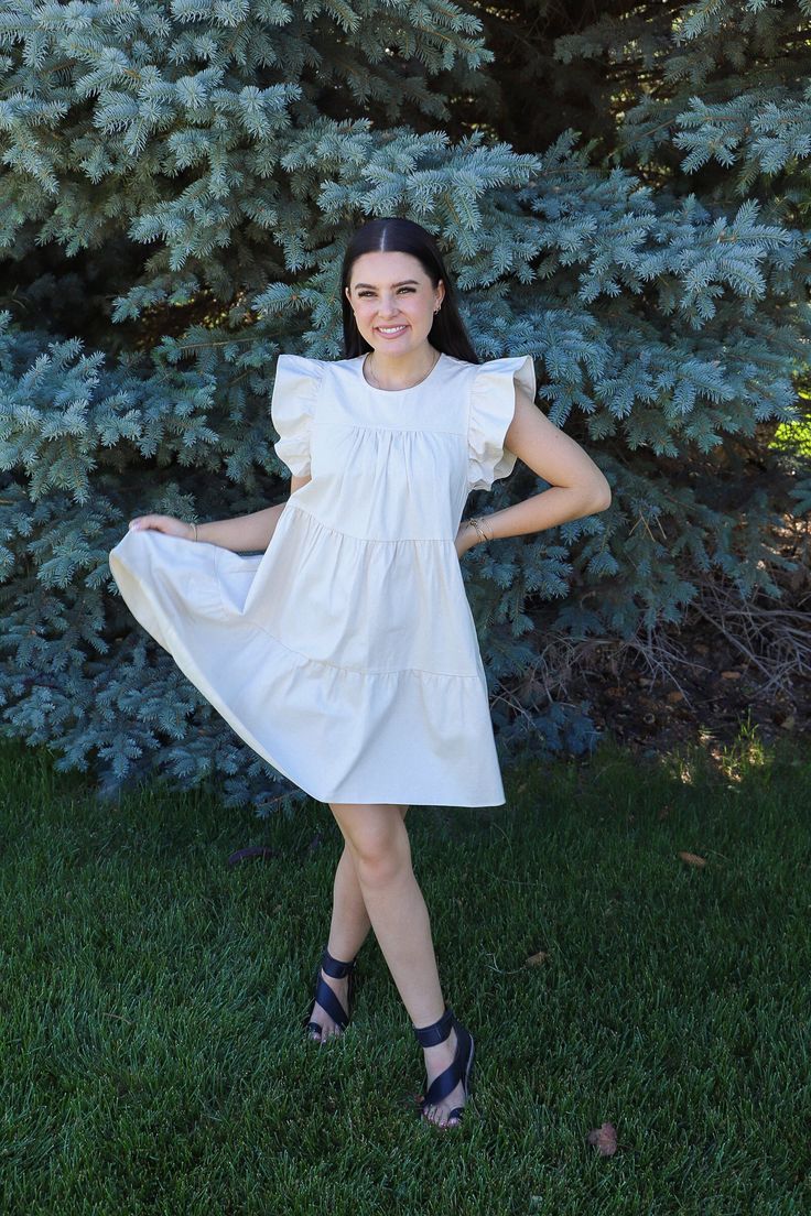 This dress could not be more perfect for summer. We love a neutral dress around here that pairs with absolutely everything! You would not believe the quality of this dress. I wish you could reach through the screen and feel it right now. Just take my word for it. Unreal ruffle sleeves with the cutest tiers AND pockets. Running true to size. Malorie is 5'6" and wearing a size medium. Beige A-line Dress With Ruffle Hem, Brunch Tiered Dress With Flutter Sleeve And Ruffle Hem, Flutter Sleeve Tiered Dress With Ruffle Hem For Brunch, Brunch Flutter Sleeve Tiered Dress With Ruffle Hem, Spring Tiered Flutter Sleeve Dress With Ruffle Hem, Spring Tiered Dress With Ruffle Hem And Flutter Sleeves, Casual Tiered Dress With Flutter Sleeves And Ruffles, Cotton Midi Dress With Ruffles For Day Out, Ruffle Sleeve Midi Dress For Garden Party