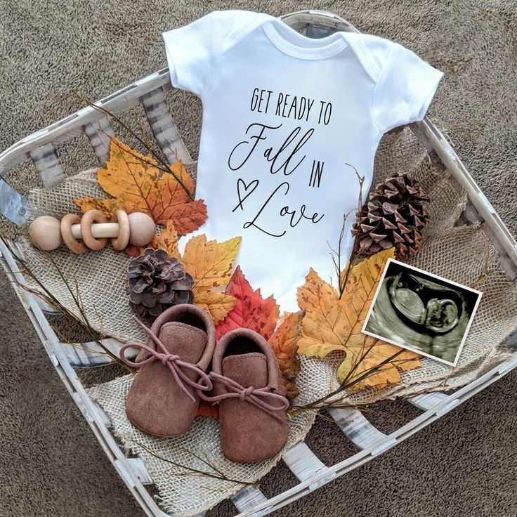 a basket filled with baby clothes and pine cones