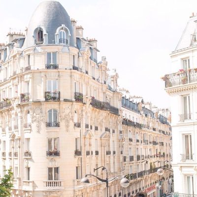 the building has many windows and balconies on it's sides, along with other buildings