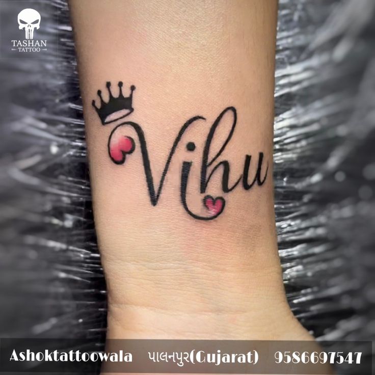 a small wrist tattoo with the word viku and hearts in black ink on it