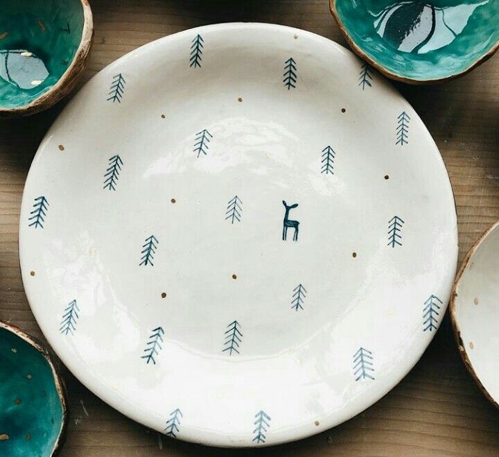 several bowls with designs on them sitting on a wooden table next to other plates and bowls