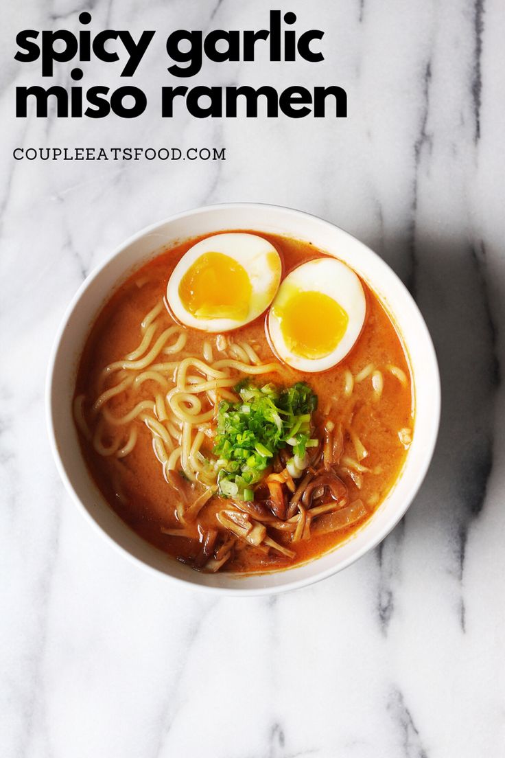 a bowl of ramen with two boiled eggs and garnishes on top