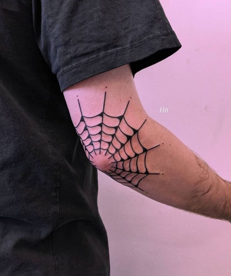 a man with a spider web tattoo on his arm