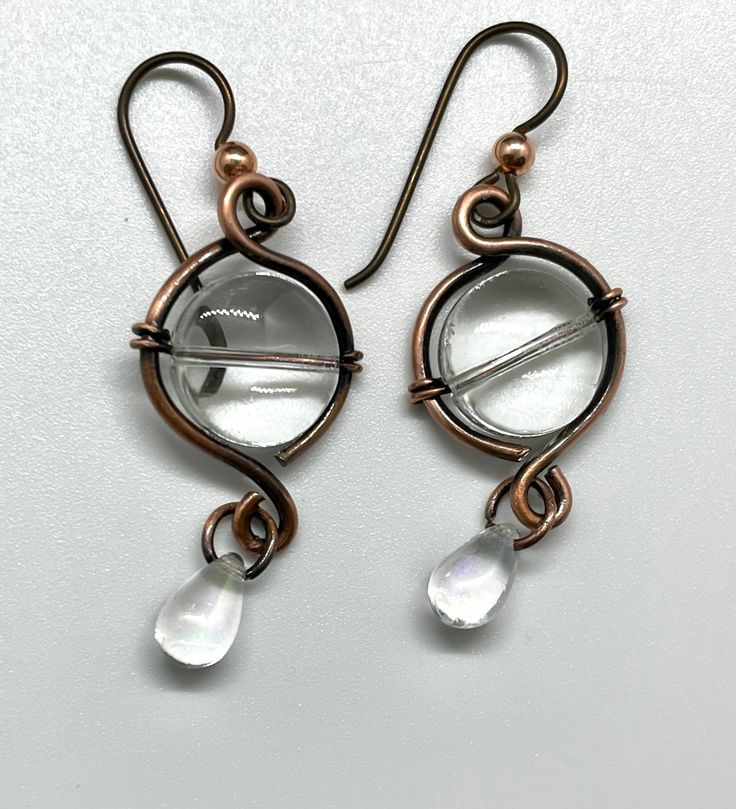 Copper Earrings with Glass Beads and an Iridescent Glass Teardrop Dangle on Niobium Ear Wires. Niobium, which is naturally hypoallergenic, making this ear wire especially suited for customers with metal sensitivities. Approximately 1 3/4" long from the top of the ear wire and 5/8" wide. These Earrings have been antiqued, polished and sealed. Sealed with Protectaclear. ProtectaClear is a clear, protective coating that is tough enough to protect jewelry and is safe for wear against skin. ProtectaC Hypoallergenic Glass Teardrop Jewelry, Adjustable Teardrop Glass Earrings, Wire Wrapped Teardrop Glass Earrings, Wire Wrapped Glass Teardrop Earrings, Teardrop Wire Wrapped Glass Earrings, Hypoallergenic Dangle Earrings With Copper Wire, Earring Ideas, Wrap Jewelry, The Ear