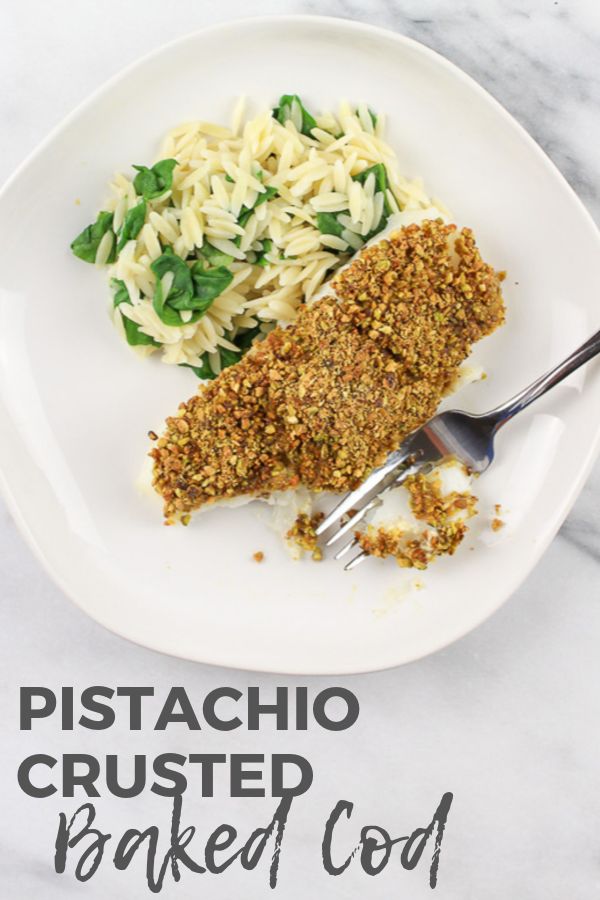 a white plate topped with pasta and meat covered in seasoning next to a fork