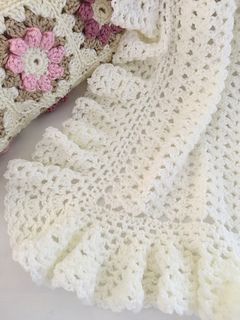 a white crocheted blanket laying on top of a table