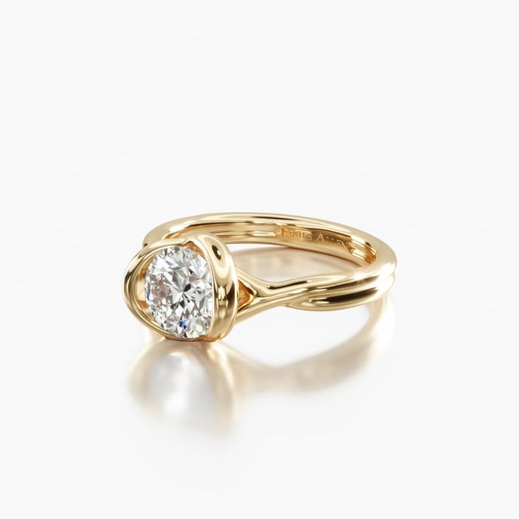 a yellow gold engagement ring with a round diamond in the center, on a white background