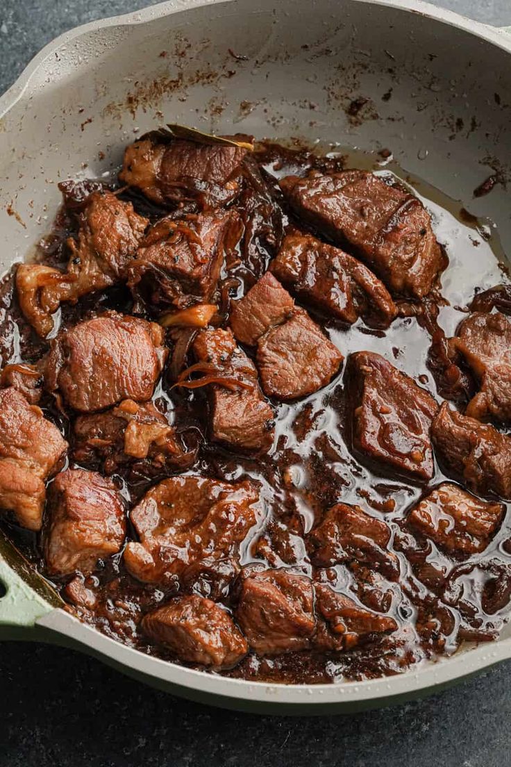 a pot filled with meat and sauce on top of a table