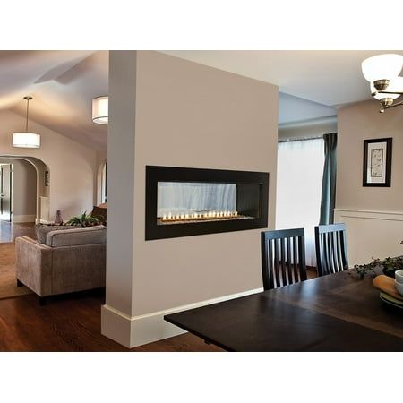 a dining room table with chairs and a fire place in the middle of it,