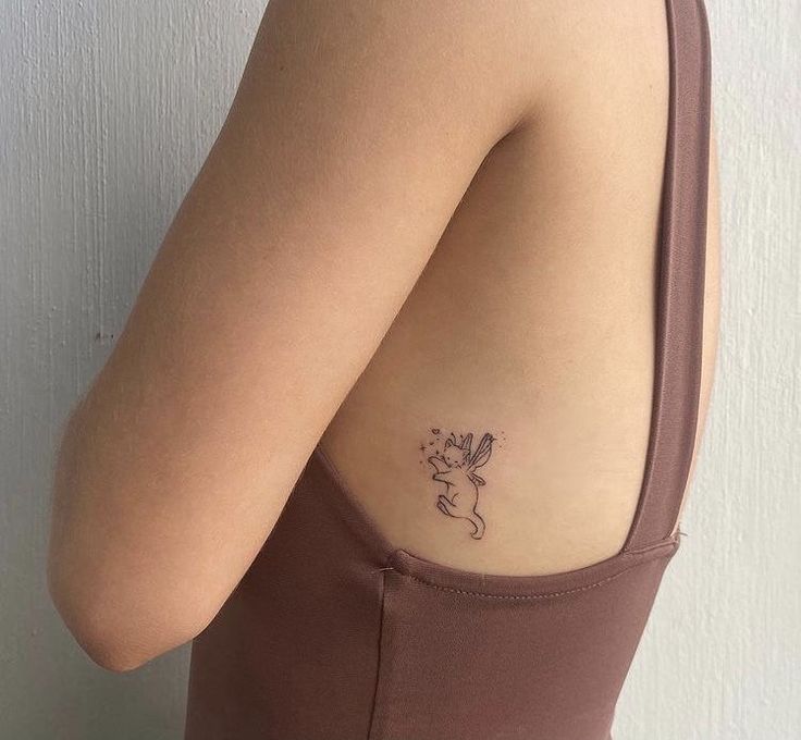 a woman with a small tattoo on her shoulder