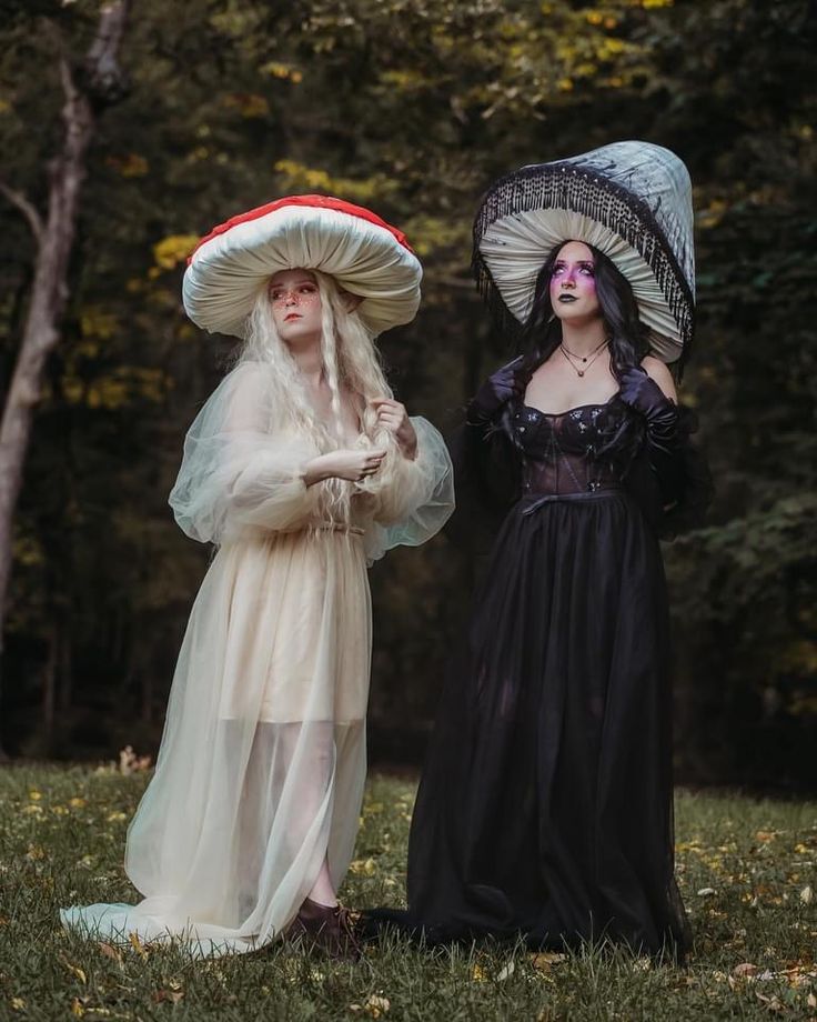 two women dressed in victorian clothing standing next to each other with hats on their heads