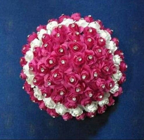 a pink and white flower arrangement on a blue surface