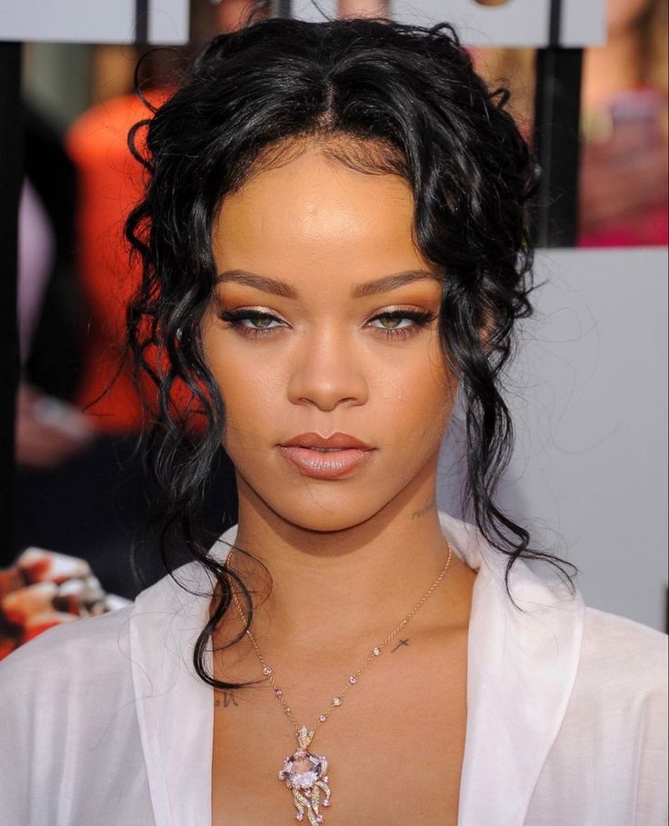 a close up of a person wearing a white shirt and some necklaces on her neck