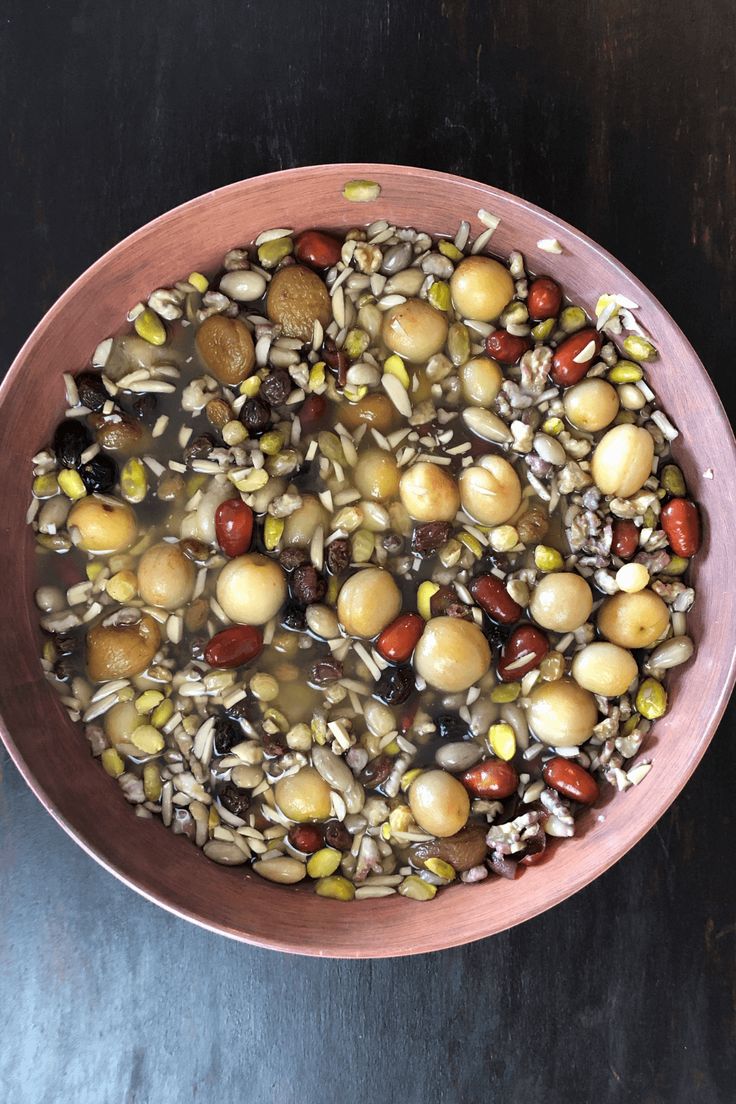 a bowl filled with nuts and seeds on top of a table