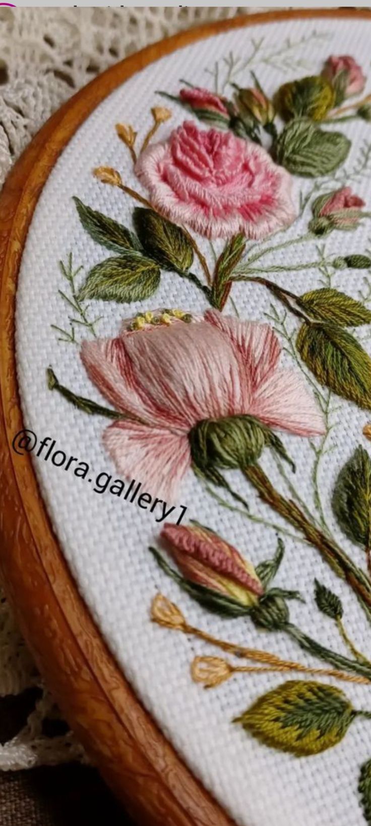 a close up of a embroidery on a piece of cloth with flowers in the middle