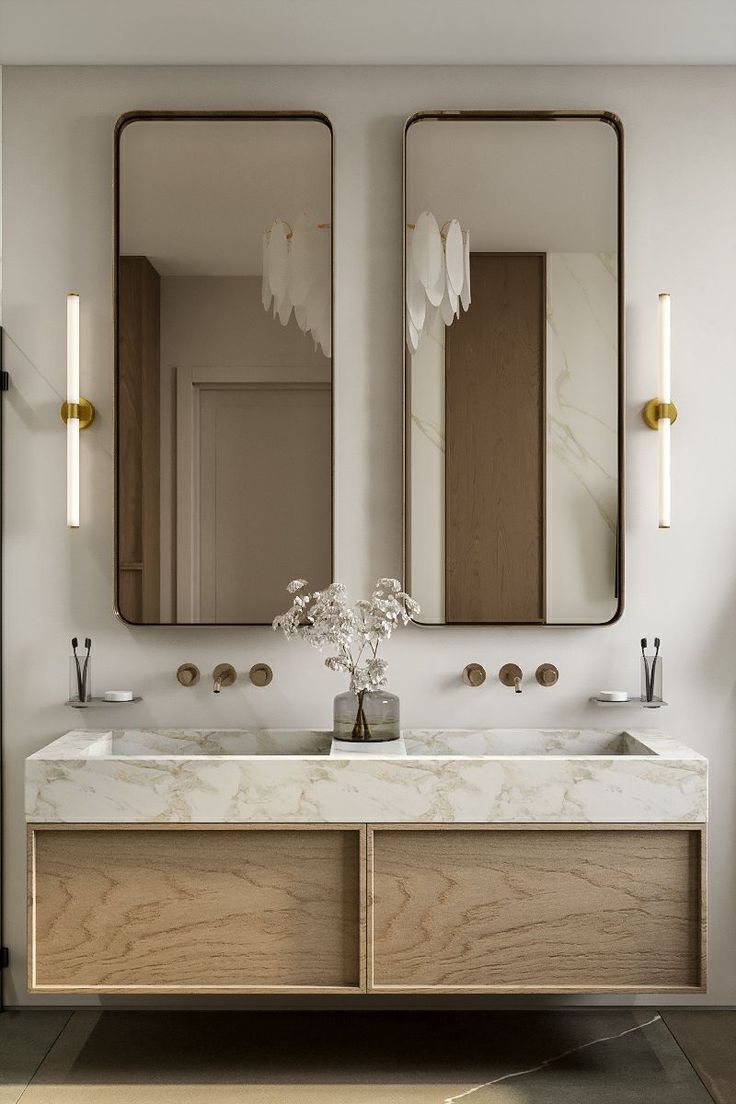 a bathroom with two sinks and mirrors on the wall