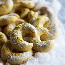 powdered donuts sitting on top of a white paper towel covered in yellow sprinkles