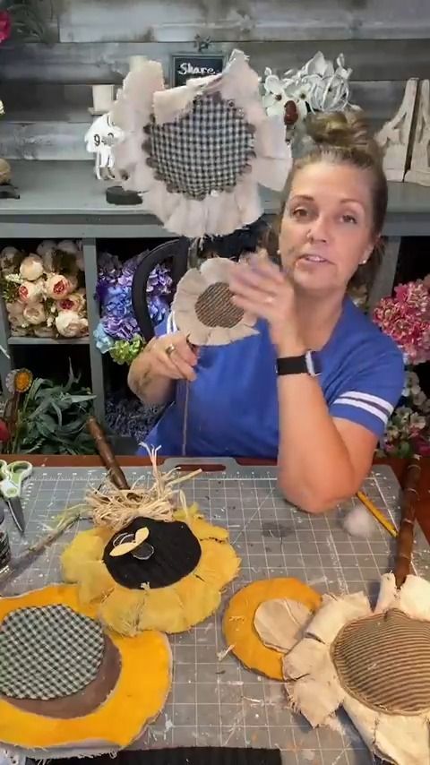 a woman sitting at a table making decorative items