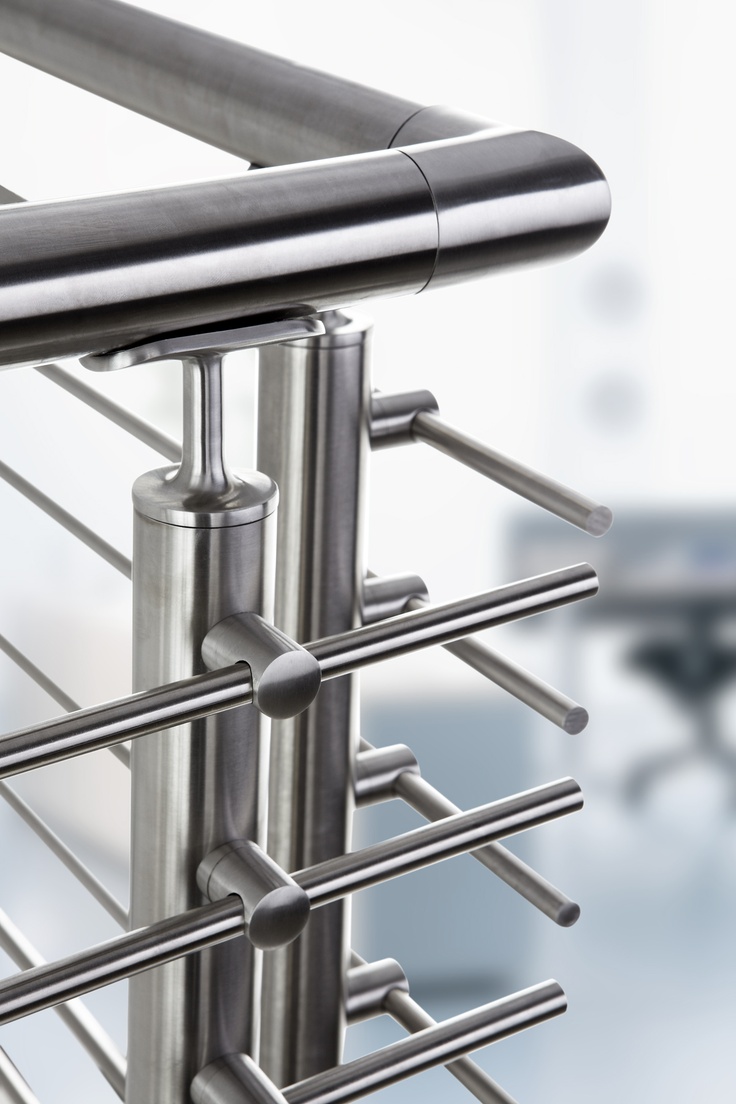 an image of a stainless steel rack with bars attached to it and chairs in the background