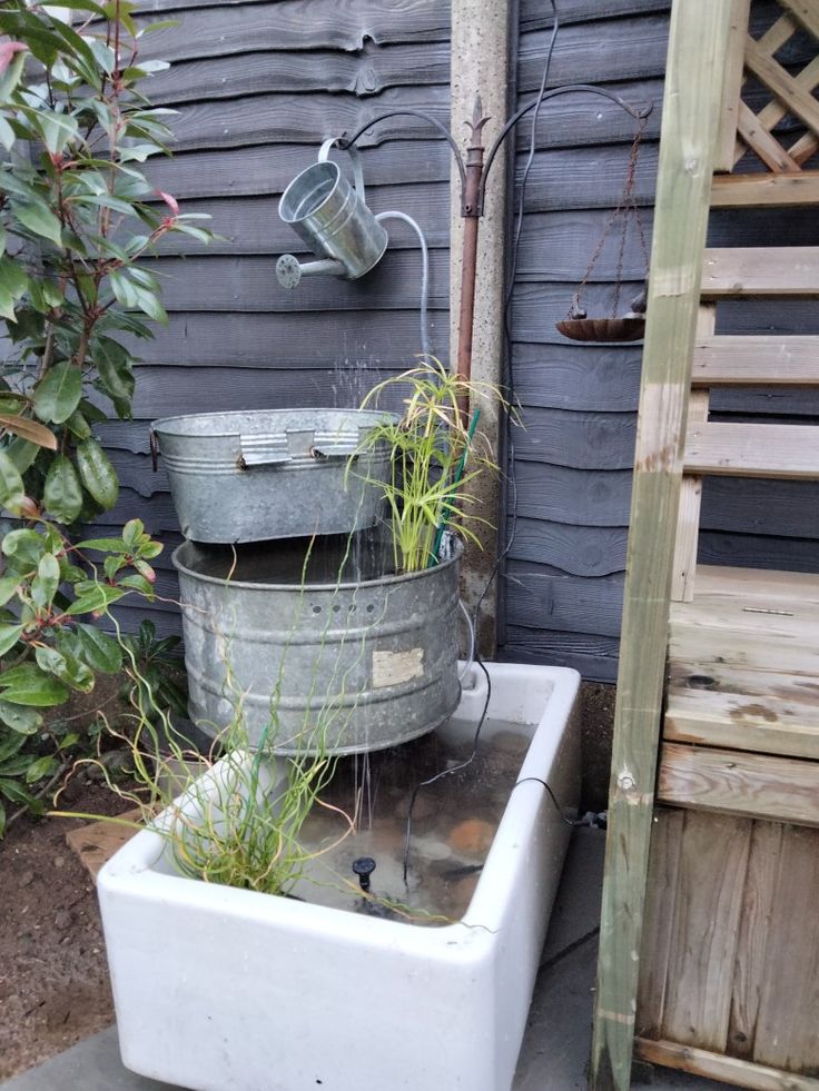 two buckets are stacked on top of each other with plants growing out of them