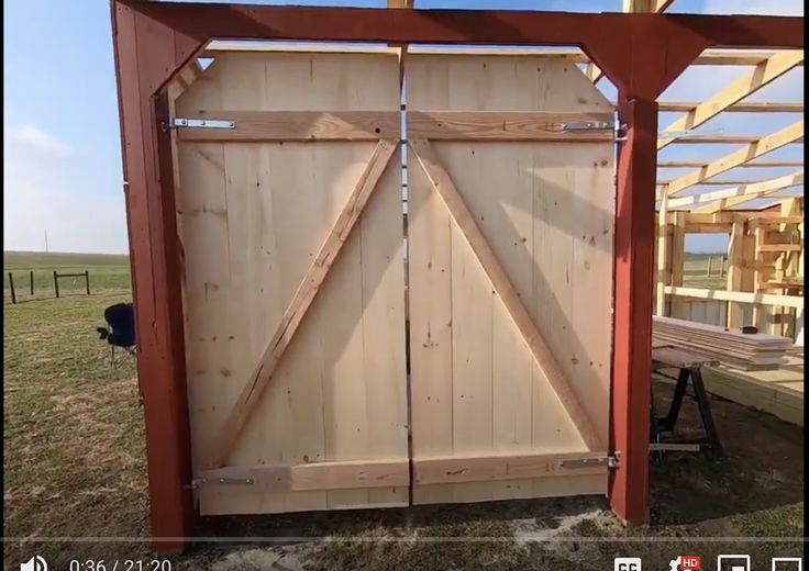 an open barn door in the middle of a field