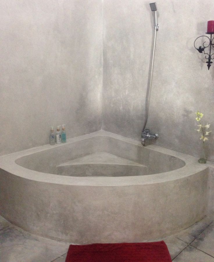 a bathroom with a red rug on the floor and a bathtub in the corner