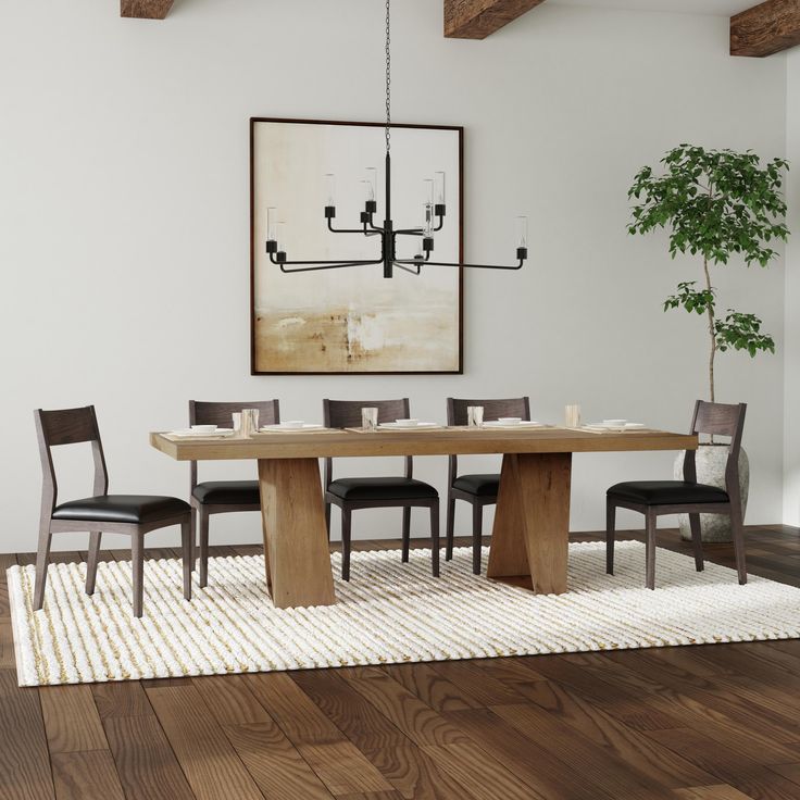 a dining room table with four chairs and a potted plant