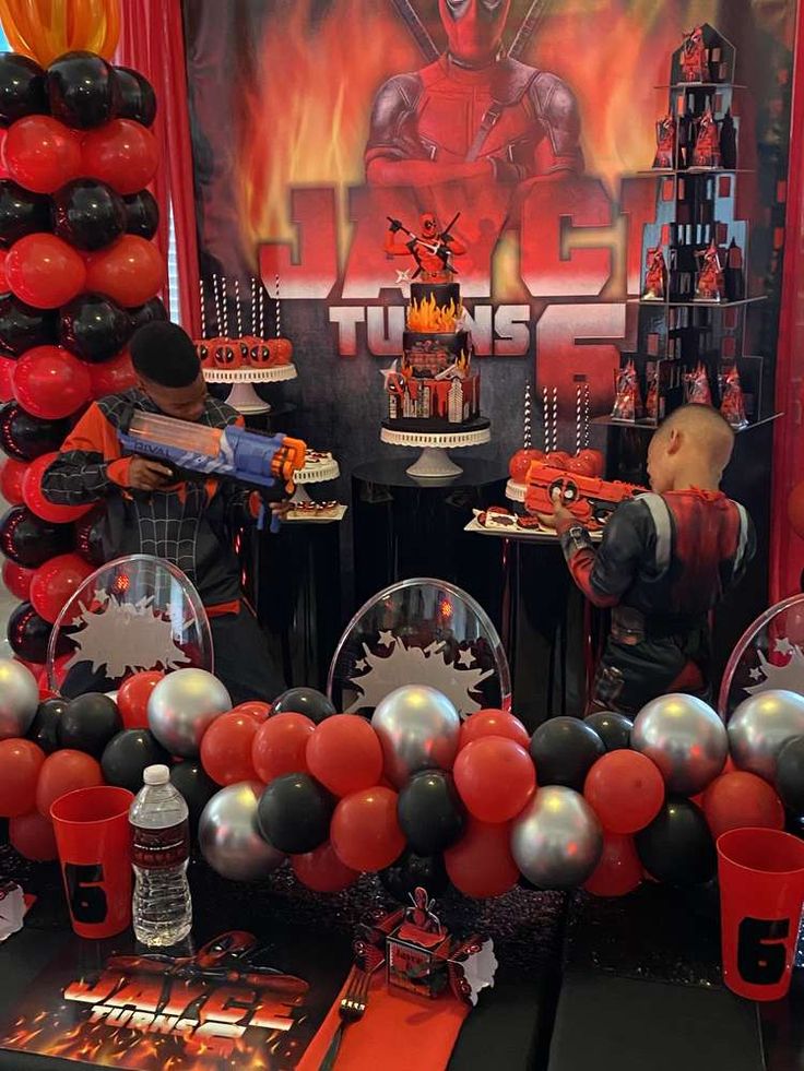 an assortment of balloons and decorations for a deadpool birthday party at a children's party