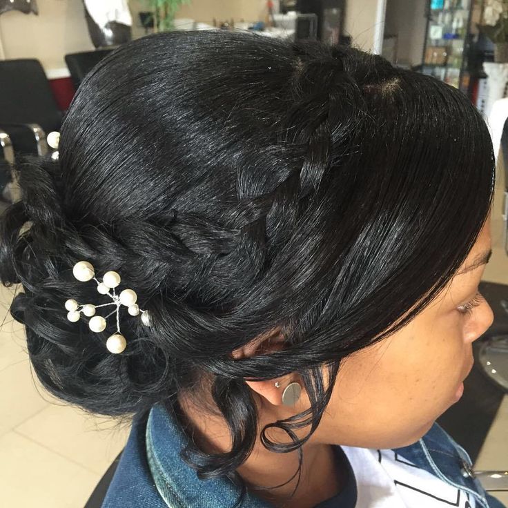 a woman is getting her hair done in a salon with pearls on the side of her head