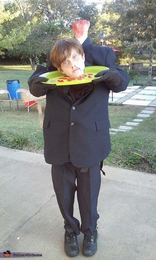 a man in a suit and tie holding a plate with food on it's face