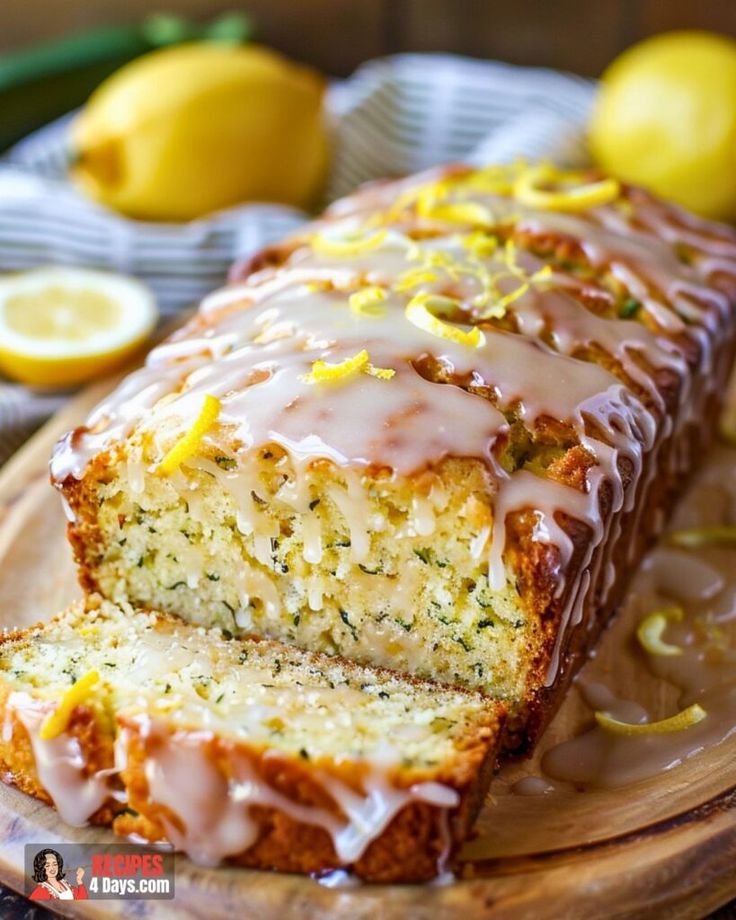 a loaf of lemon zucchini bread on a cutting board with sliced lemons in the background