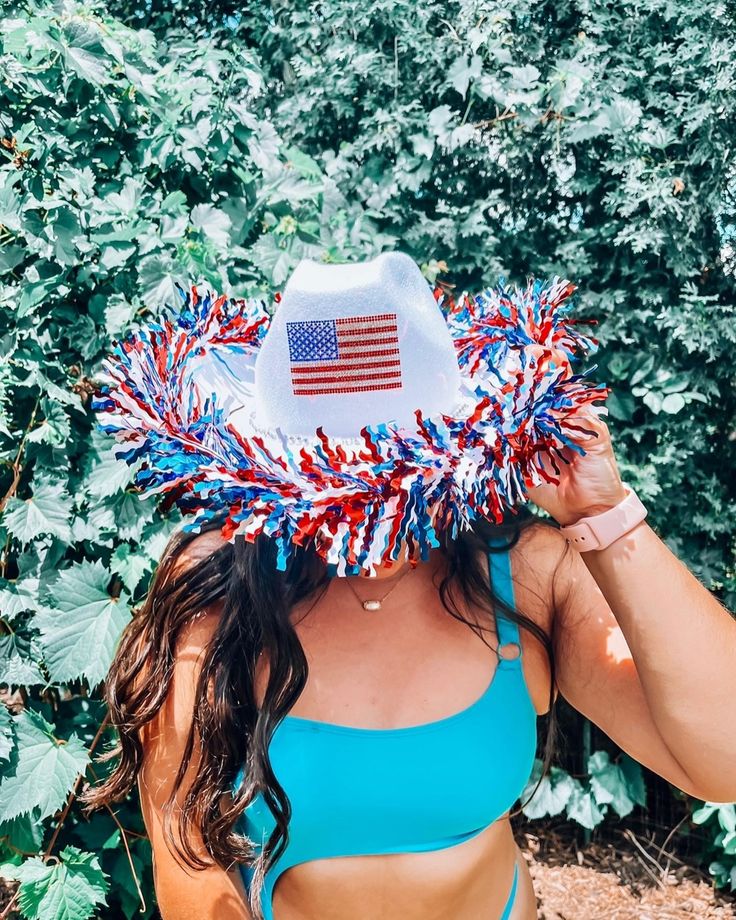 a woman wearing a straw hat with an american flag decoration on it's brim