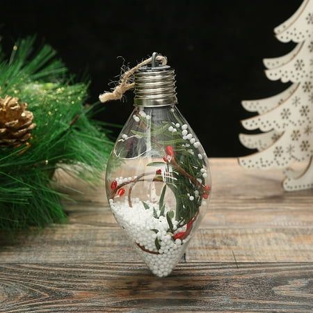 a christmas ornament is sitting on a table next to pine cones and fir trees