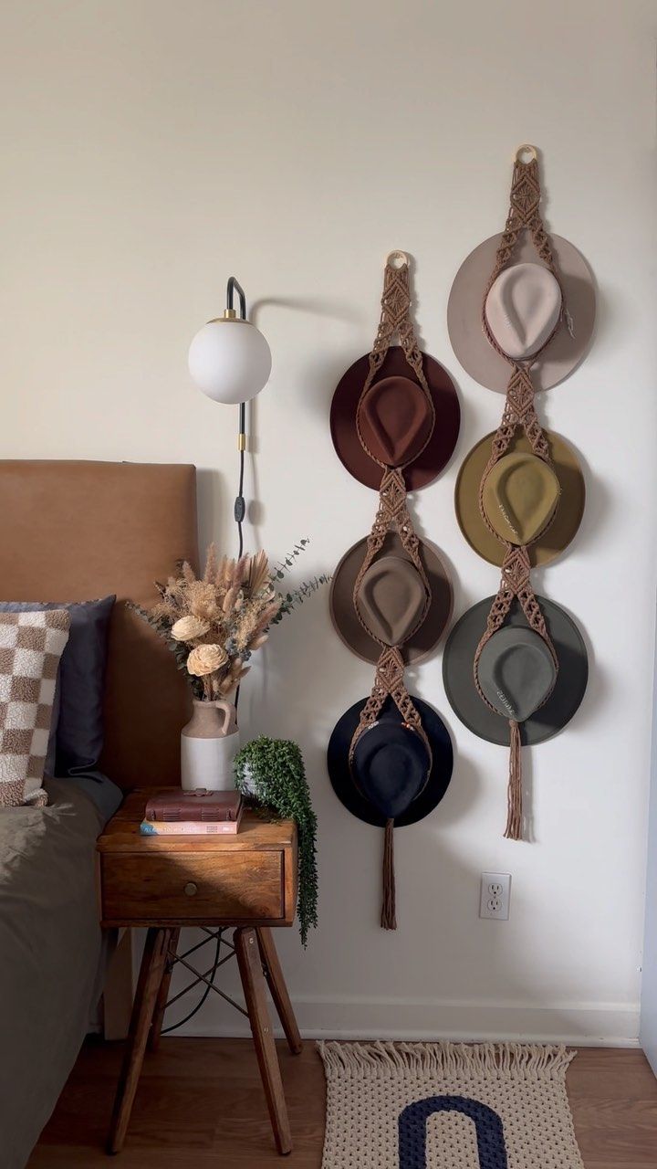 hats are hanging on the wall above a bed