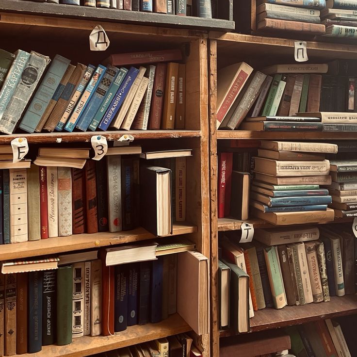 a book shelf filled with lots of books on top of wooden shelves next to each other