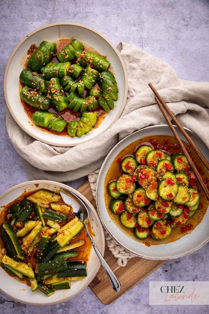 two bowls filled with vegetables next to chopsticks