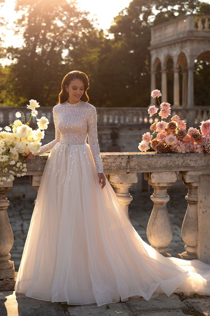 a woman in a wedding dress standing next to flowers