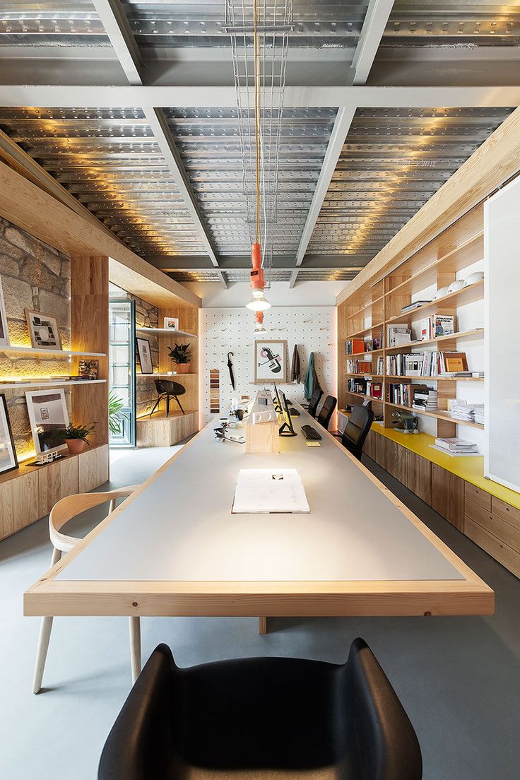 a long table in the middle of a room with lots of bookshelves and chairs