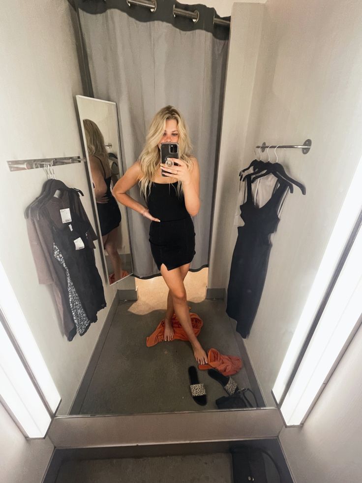 a woman taking a selfie in front of a mirror with shoes on the floor