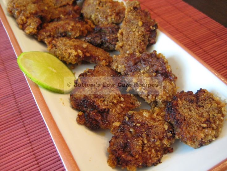 some fried food on a white plate with a lime