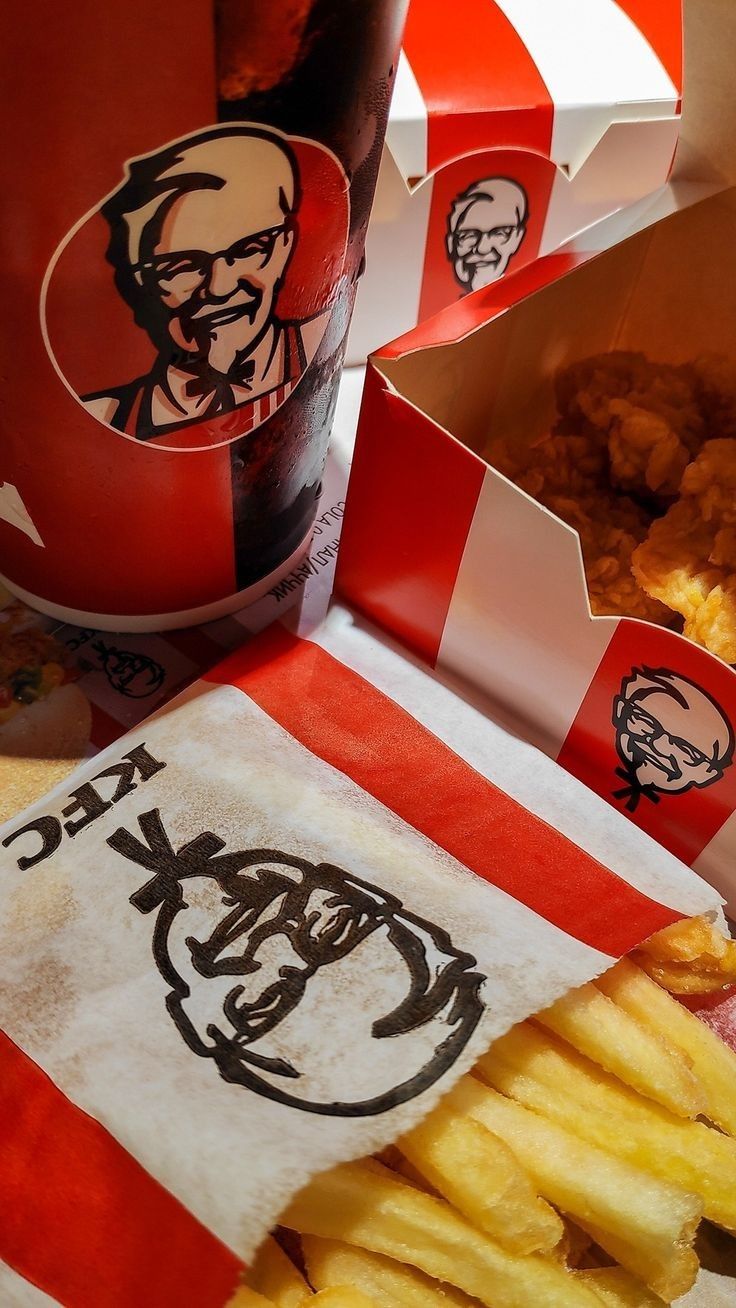 french fries and ketchup are sitting next to a bottle of kfc's