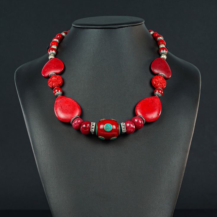 This unusual red Necklace is 20 1/4" long made with a Tibetan oval centerpiece of Enamel and Turquoise (30x20mm) framed with 4 faceted red Jade rondels, red  Howlite ovals and hearts and Tibetan red , silver ended 9mm decorative beads to frame the Sterling lobster clasp (10x20mm) Artisan Red Gemstone Jewelry, Artisan Red Oval Jewelry, Red Costume Jewelry For Valentine's Day, Red Beaded Necklaces With Natural Stones, Red Beaded Necklaces With Natural Stones For Gift, Unique Red Jewelry With Stones, Unique Red Stone Jewelry, Traditional Red Oval Jewelry, Red Necklaces With Natural Stones And Round Beads