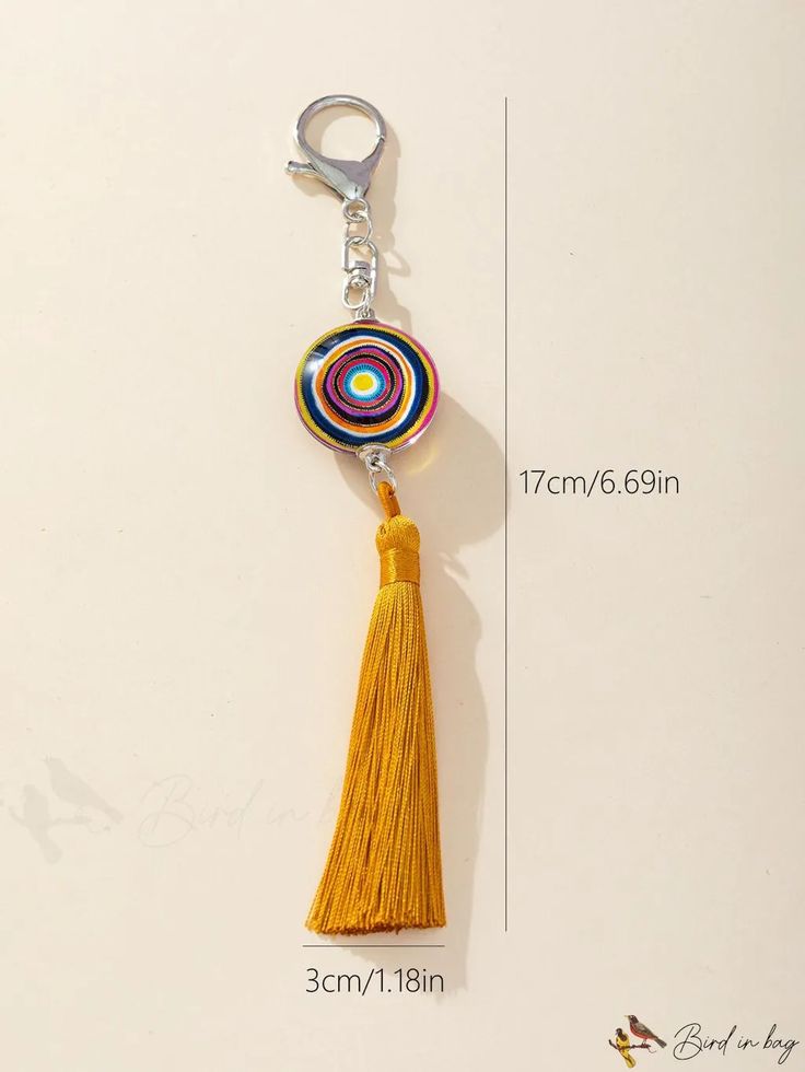 a yellow tasseled keychain with a circular bead on the end