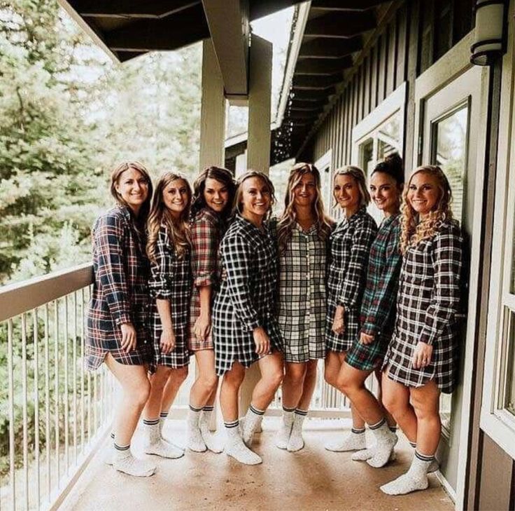 a group of young women standing on top of a porch next to eachother