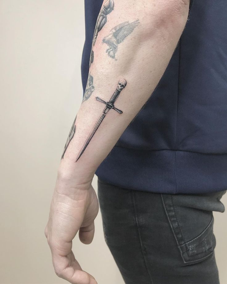 a man with a cross tattoo on his arm